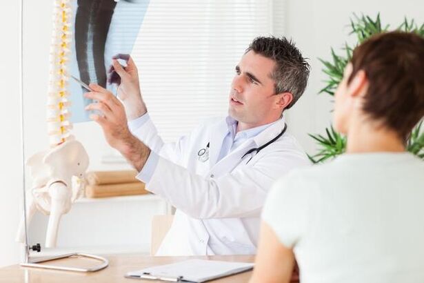 il medico mostra il danno alla colonna vertebrale dovuto all'osteocondrosi cervicale